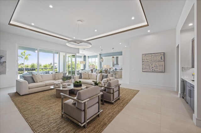 living room featuring beverage cooler, a raised ceiling, and indoor wet bar