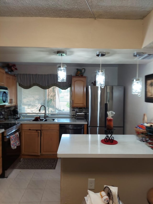 kitchen featuring appliances with stainless steel finishes, light tile patterned floors, sink, and hanging light fixtures