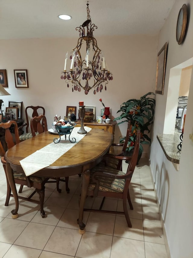 dining area featuring light tile patterned flooring and an inviting chandelier