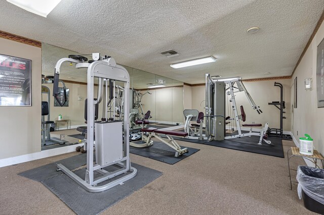 gym with ornamental molding and a textured ceiling