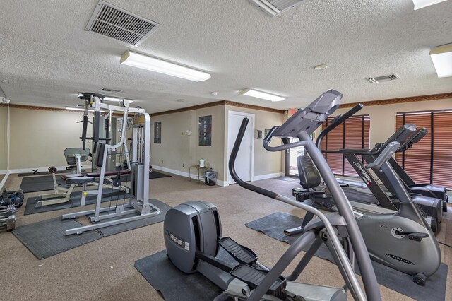 workout area with crown molding and a textured ceiling