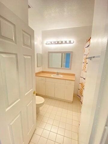 bathroom featuring tile patterned floors, toilet, and vanity