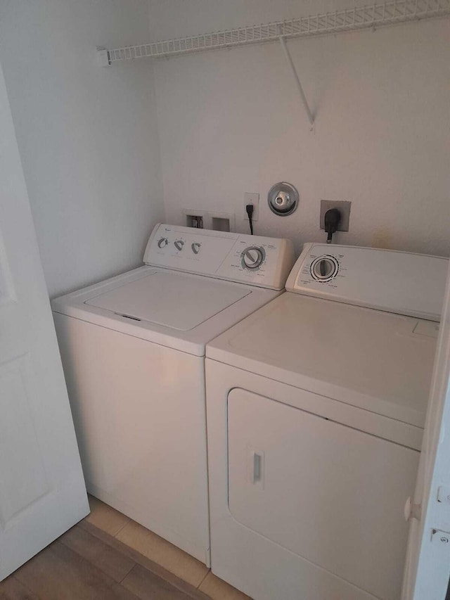 washroom featuring washer and clothes dryer and light hardwood / wood-style floors