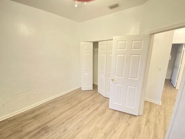 unfurnished bedroom with light hardwood / wood-style flooring and a closet