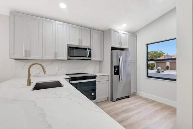 kitchen featuring light stone countertops, appliances with stainless steel finishes, sink, and white cabinetry