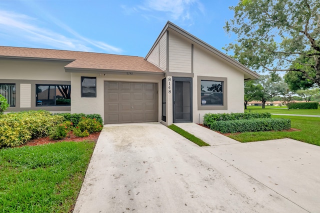 view of front of property featuring a front lawn and a garage