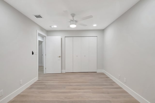 unfurnished bedroom with ceiling fan, light hardwood / wood-style flooring, and a closet