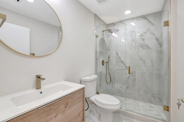 bathroom featuring toilet, vanity, and a shower with shower door