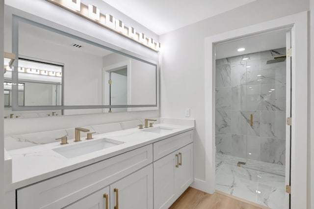 bathroom with vanity, hardwood / wood-style flooring, and tiled shower