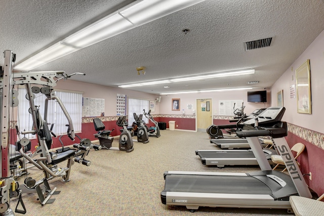 gym featuring carpet and a textured ceiling