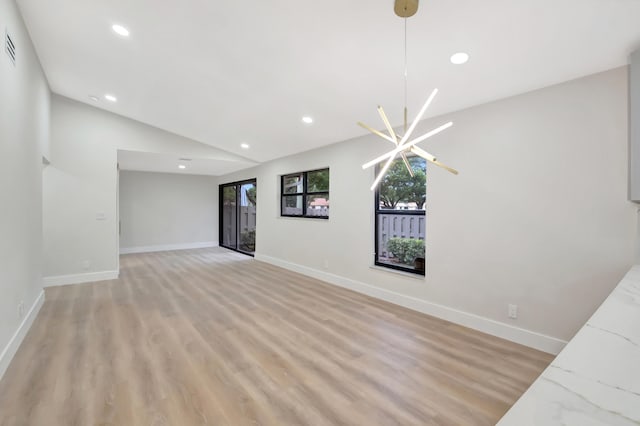 unfurnished living room with vaulted ceiling and light hardwood / wood-style flooring