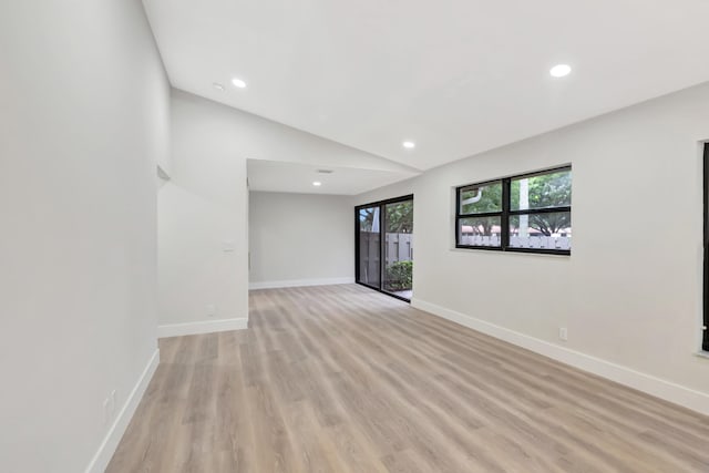 unfurnished room featuring light hardwood / wood-style floors and vaulted ceiling