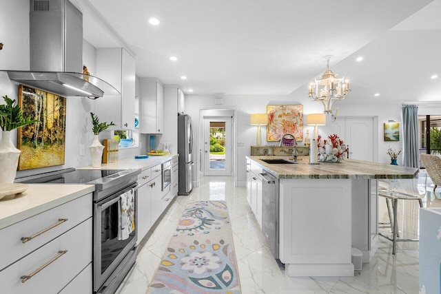 kitchen with white cabinets, appliances with stainless steel finishes, sink, island range hood, and a kitchen island with sink