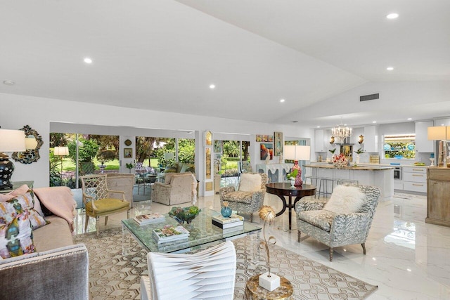 living room with lofted ceiling, a healthy amount of sunlight, and an inviting chandelier