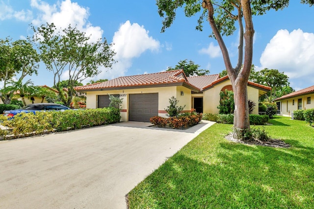 mediterranean / spanish-style house featuring a garage and a front lawn