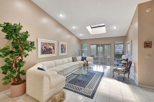 living room with a skylight, high vaulted ceiling, and light tile patterned flooring