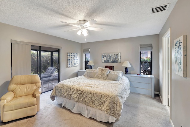 carpeted bedroom featuring ceiling fan, access to outside, and a textured ceiling