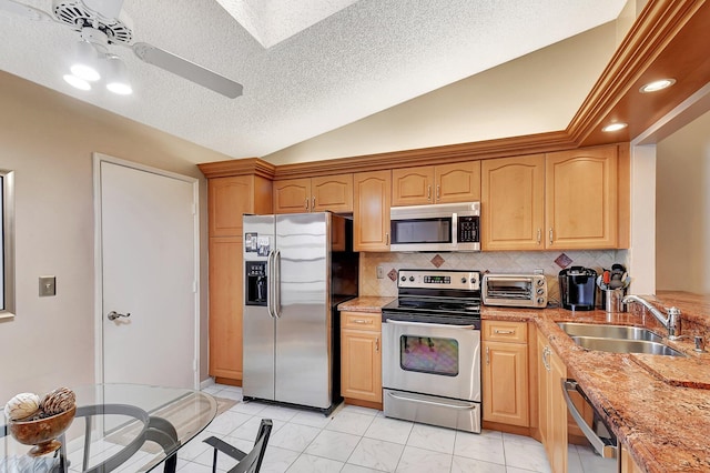 kitchen featuring a textured ceiling, sink, light stone countertops, and appliances with stainless steel finishes