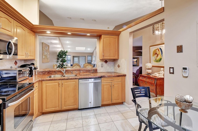 kitchen featuring appliances with stainless steel finishes, backsplash, sink, and dark stone counters