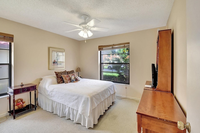 carpeted bedroom featuring a textured ceiling and ceiling fan