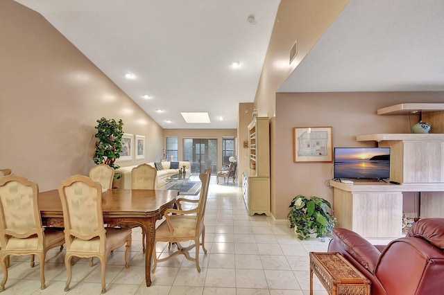 tiled dining area featuring vaulted ceiling