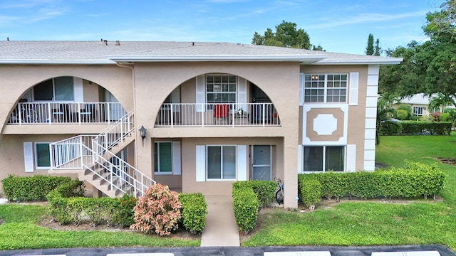 exterior space with a balcony and a front lawn