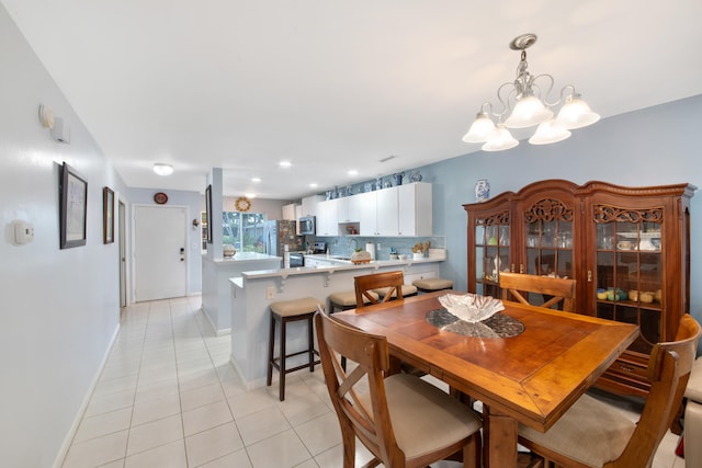 dining room with light tile patterned flooring and a notable chandelier