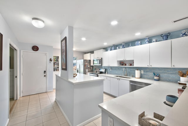 kitchen with a kitchen island, stainless steel appliances, sink, and white cabinets