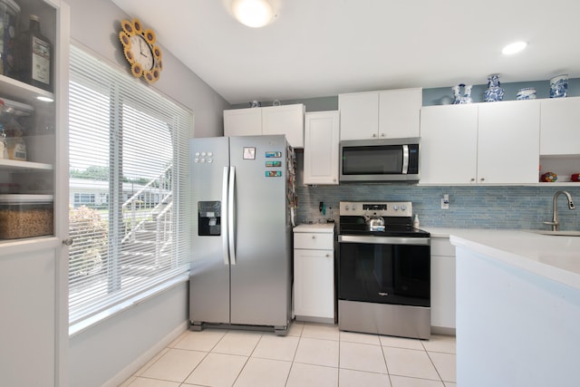 kitchen featuring appliances with stainless steel finishes, a wealth of natural light, sink, and white cabinets