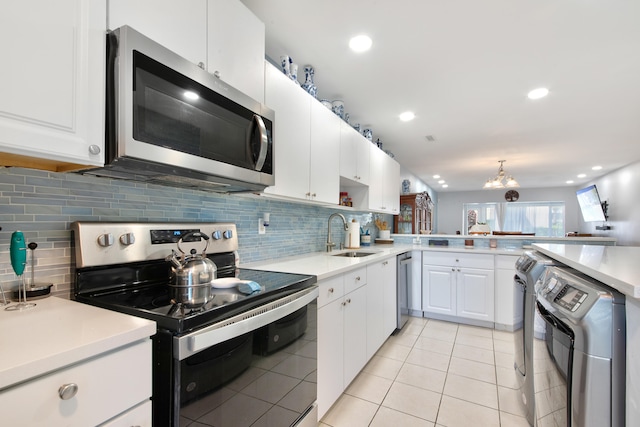 kitchen with an inviting chandelier, washer / clothes dryer, stainless steel appliances, sink, and white cabinets