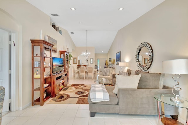 living room with light tile patterned floors, an inviting chandelier, and vaulted ceiling