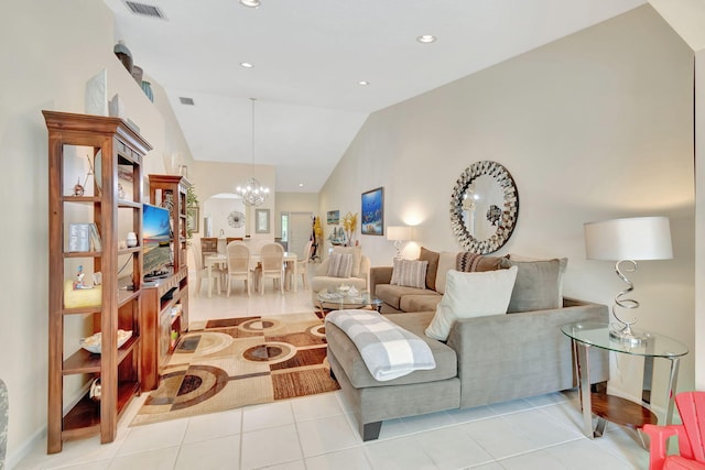 tiled living room with lofted ceiling and a notable chandelier