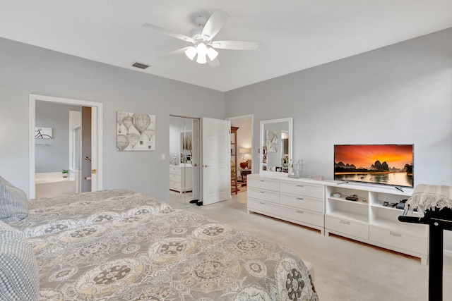 carpeted bedroom featuring a closet, ceiling fan, and ensuite bath