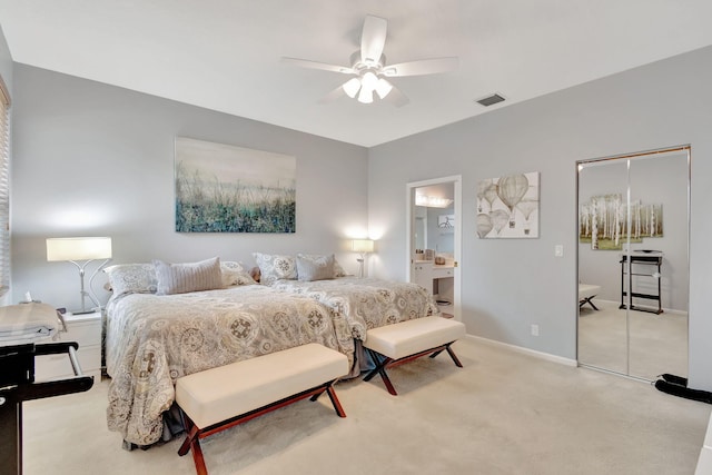 bedroom with ceiling fan, ensuite bathroom, and light carpet