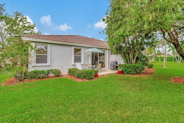 rear view of property with a yard and a patio area