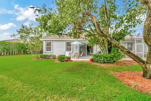 rear view of property with a yard and a patio