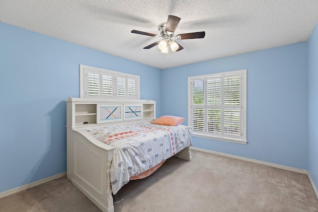 carpeted bedroom with a textured ceiling and ceiling fan