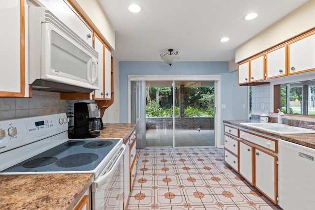 kitchen with a healthy amount of sunlight, white appliances, and white cabinetry