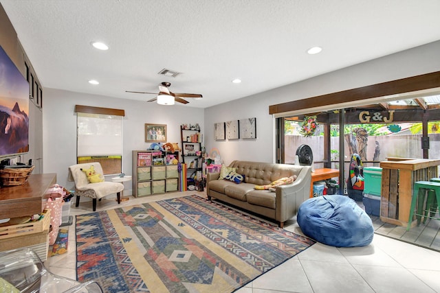 tiled living room featuring ceiling fan and a textured ceiling