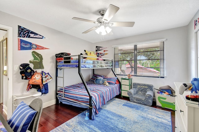 bedroom featuring ceiling fan, dark hardwood / wood-style flooring, and a textured ceiling