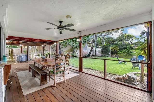 unfurnished sunroom featuring ceiling fan