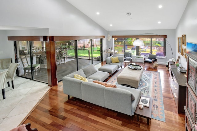 living room featuring light hardwood / wood-style floors and high vaulted ceiling