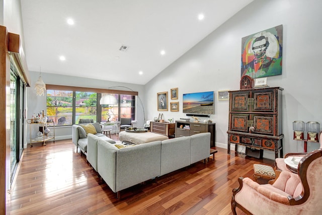 living room with high vaulted ceiling and hardwood / wood-style flooring