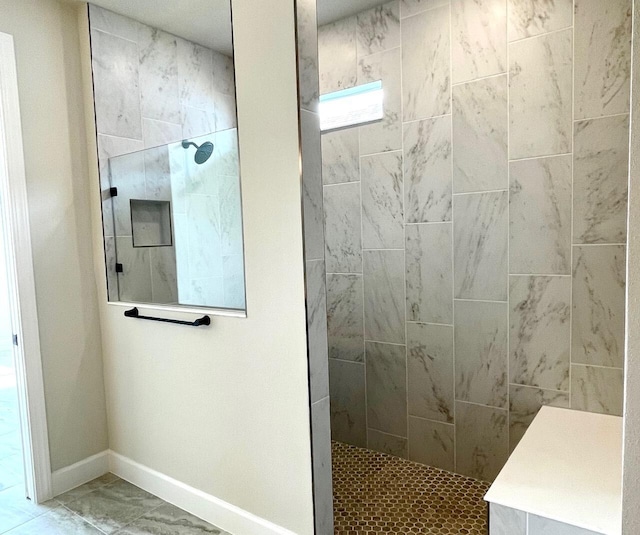 full bathroom with a walk in shower, marble finish floor, and baseboards