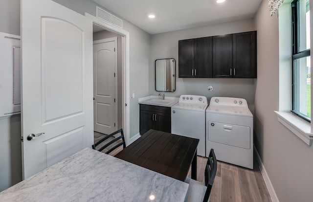 laundry room with washer and clothes dryer, cabinet space, baseboards, and a sink