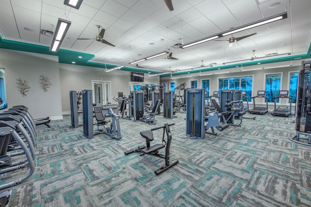 exercise room featuring a ceiling fan, carpet, and baseboards