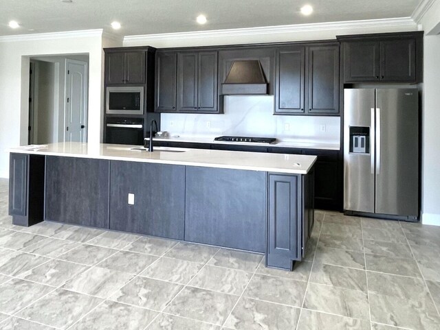 kitchen featuring a large island with sink, a sink, black appliances, custom range hood, and light countertops