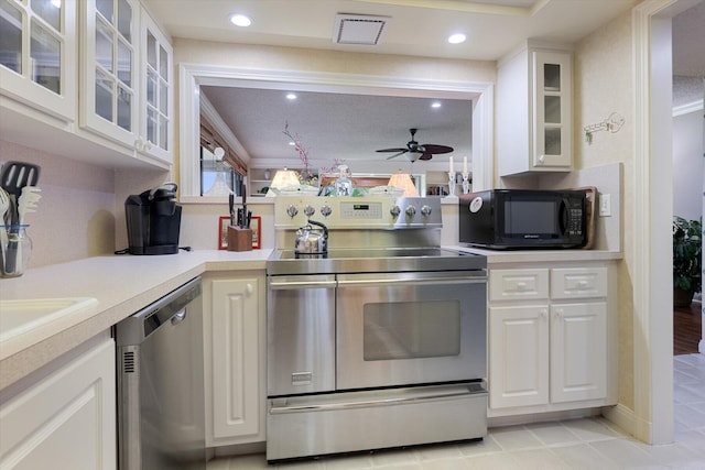 kitchen featuring ceiling fan, stainless steel appliances, white cabinetry, and ornamental molding