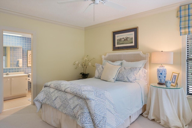 carpeted bedroom featuring crown molding, a textured ceiling, ensuite bathroom, and ceiling fan