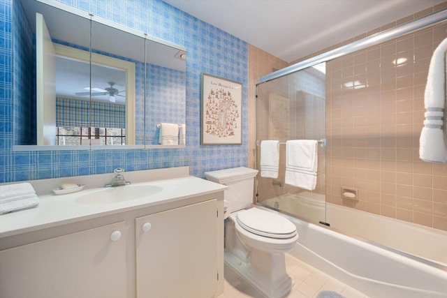 full bathroom with shower / bath combination with glass door, vanity, tile patterned flooring, toilet, and ceiling fan